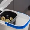 Balde do lixo pequeno encaixado no interior de um balde maior, com cápsulas de café usadas